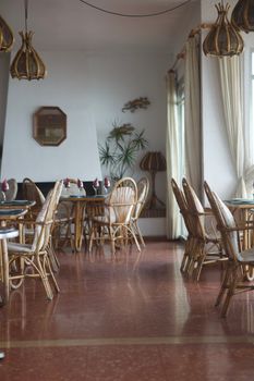 Charming indoor cafe with rattan furniture and warm decor. Perfect for relaxed dining.