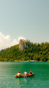Scenic view of Lake Bled with tourists boating under the iconic Bled Castle in Slovenia.