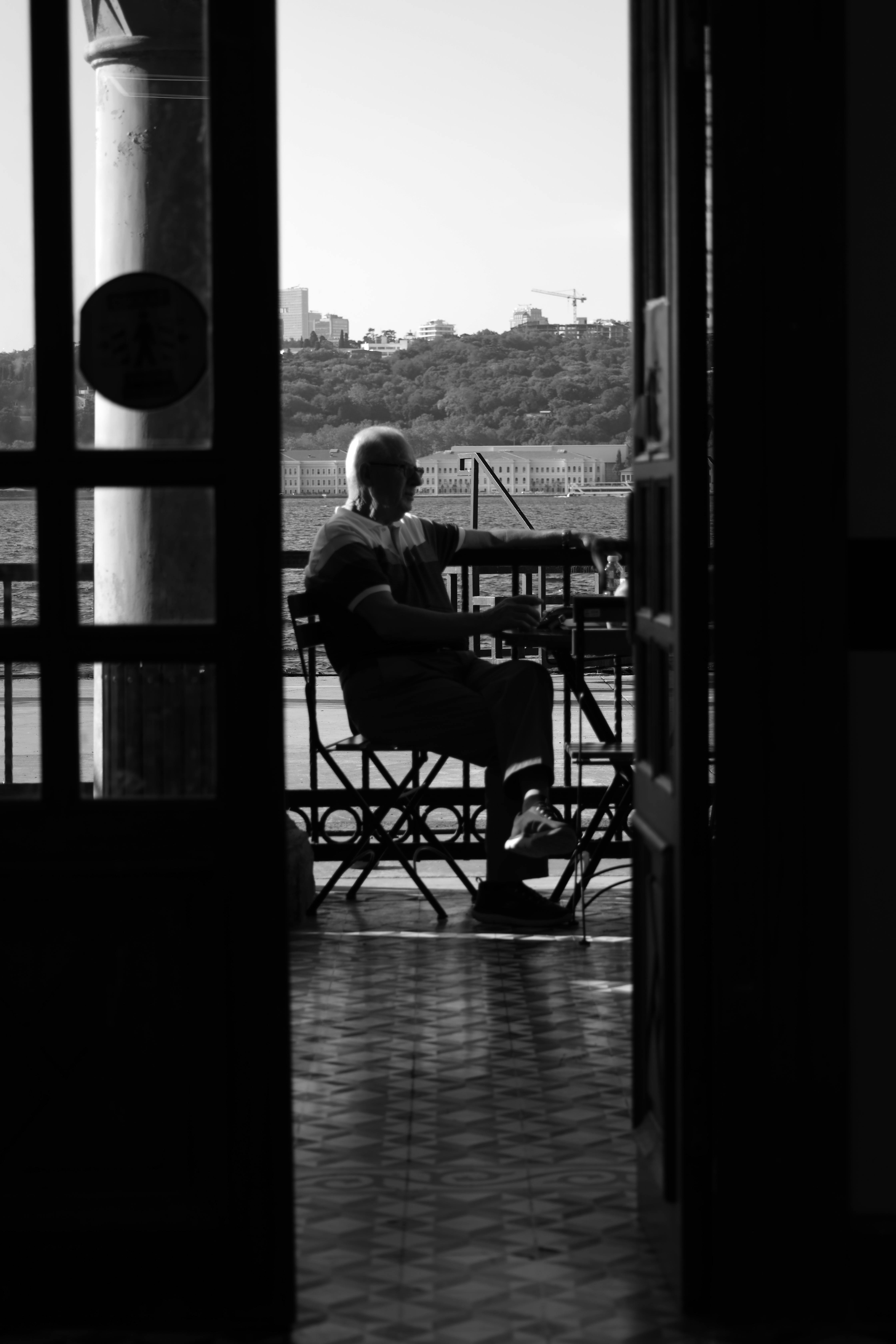 Kostenlos Eine ruhige Schwarz-Weiß-Silhouette eines Mannes in einem Istanbuler Café, aufgenommen bei Tageslicht. Stock-Foto