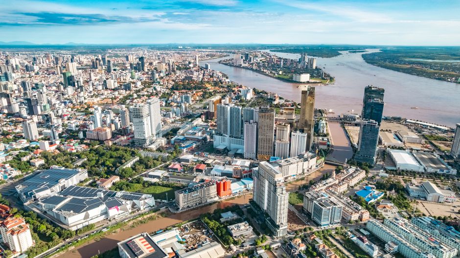 A breathtaking aerial view showcasing the bustling cityscape of Phnom Penh, Cambodia, along with the serene Mekong River.