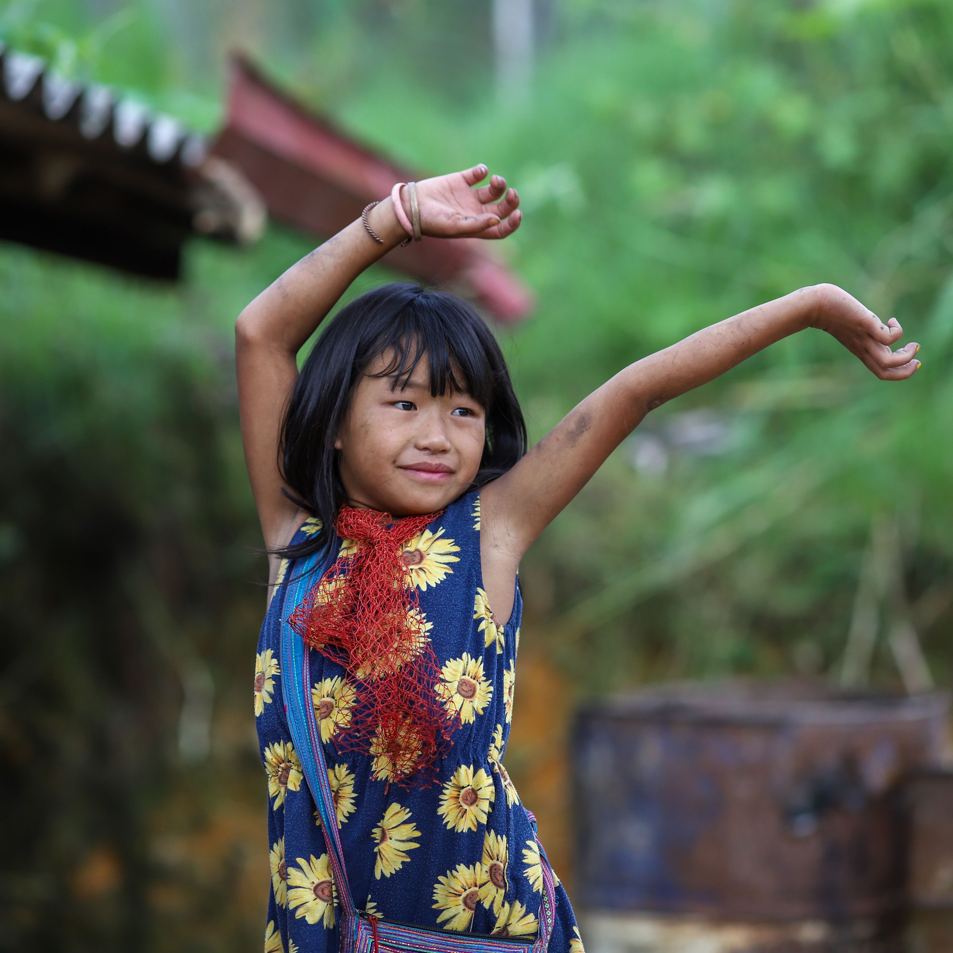 A cheerful child enjoying a sunny day outdoors in Lào Cai, Vietnam.
