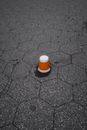 Brown and White Plastic Cup Upside Down on Gray Pavement