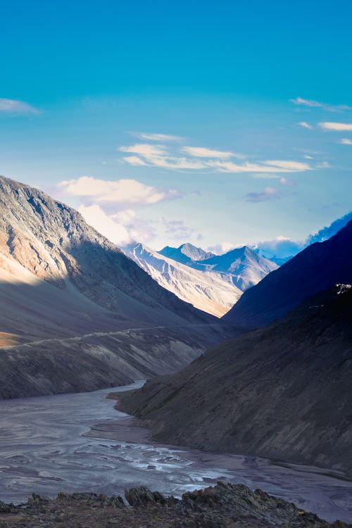 Free A breathtaking view of a river winding through a rugged mountain valley, capturing the beauty of nature. Stock Photo
