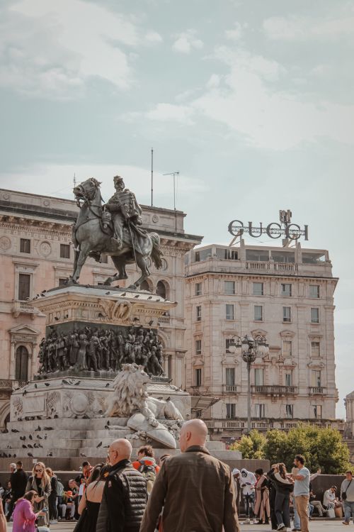 Free Bustling Piazza del Duomo with iconic statue and historic architecture in Milan. Stock Photo