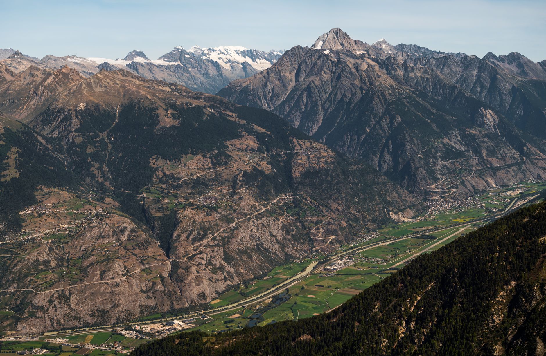 Panoramic view of Anniviers valley in Switzerland with majestic Swiss Alps under a clear blue sky.