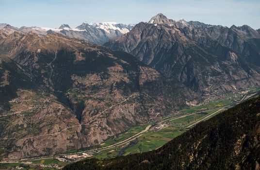 Vue panoramique de la vallée d'Anniviers en Suisse avec les majestueuses Alpes suisses sous un ciel bleu clair.
