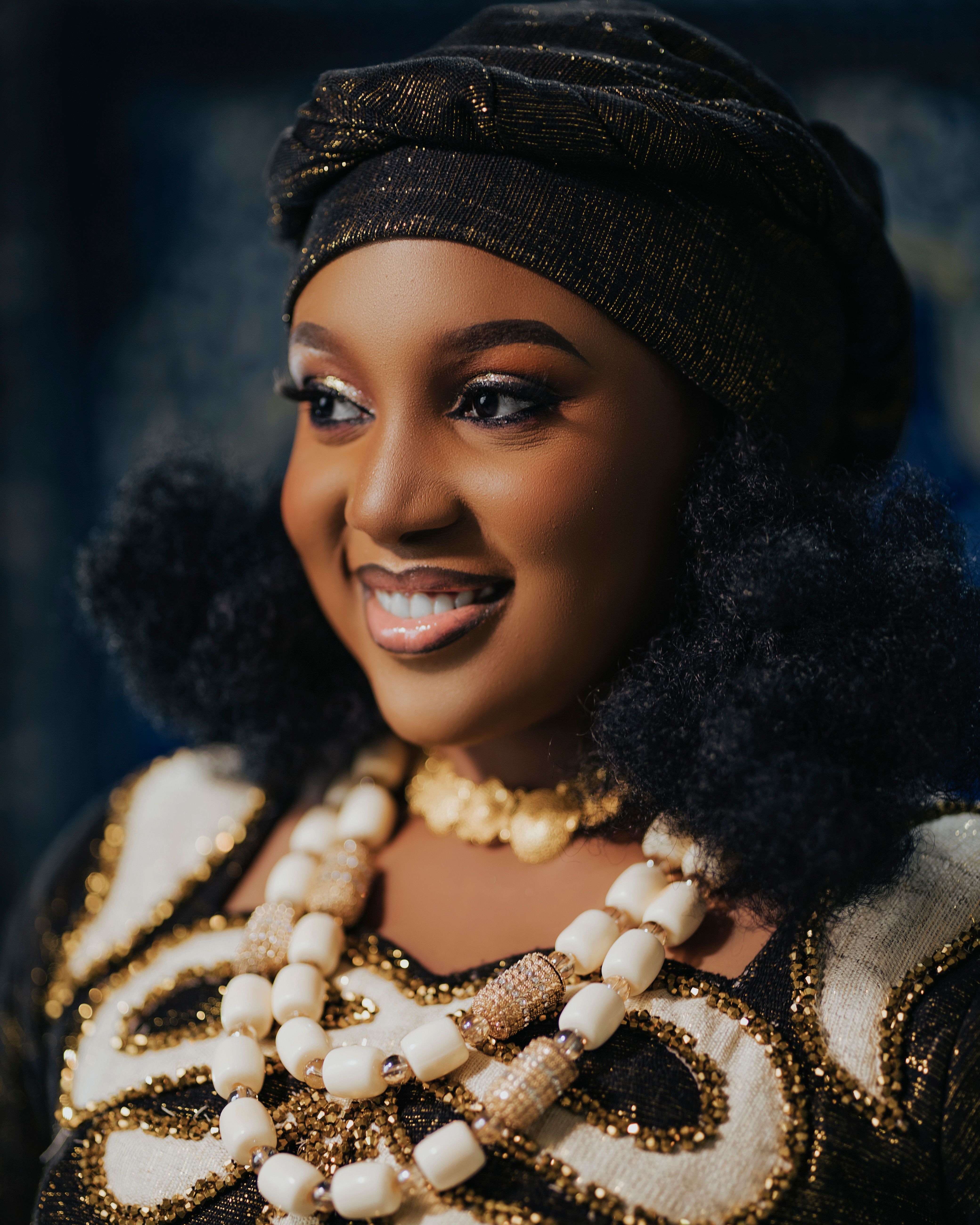 Charming portrait of a smiling African bride adorned in traditional attire and jewelry.