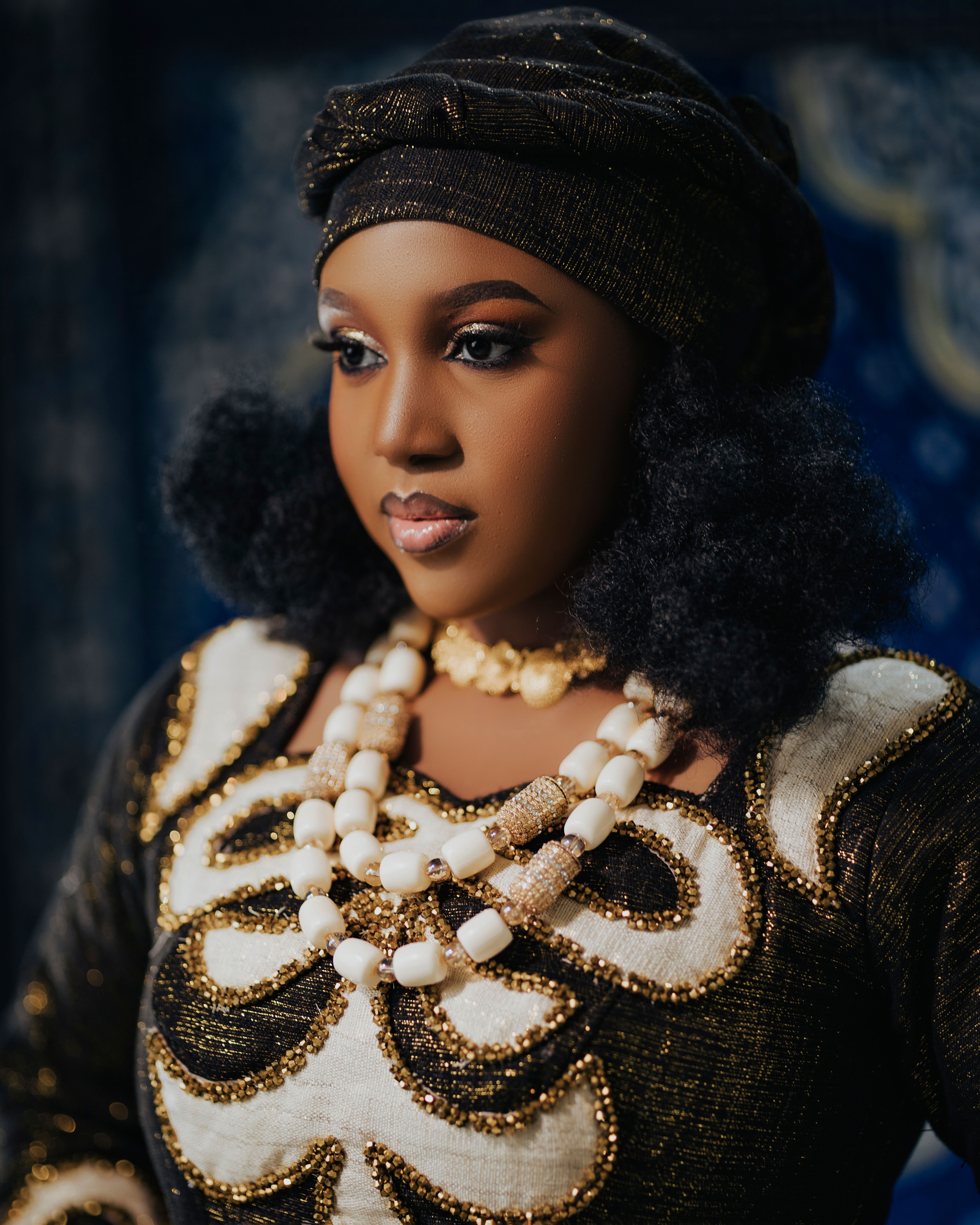 African bride in traditional attire with beaded jewelry, embodying elegance and cultural richness.