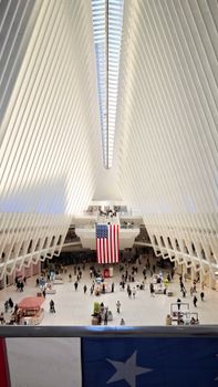 Interior view of The Oculus in NYC with people and American flag.