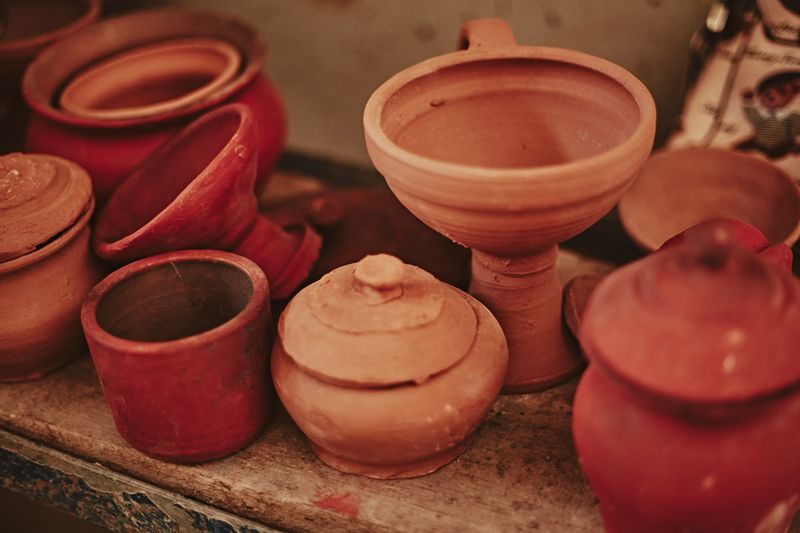 A rustic collection of earthenware pots and ceramics on display, showcasing traditional craft.