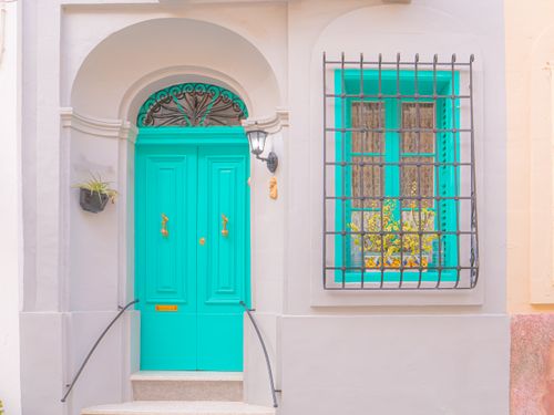 Free Bright and vibrant turquoise facade showcasing classic European architecture with decorative details. Stock Photo