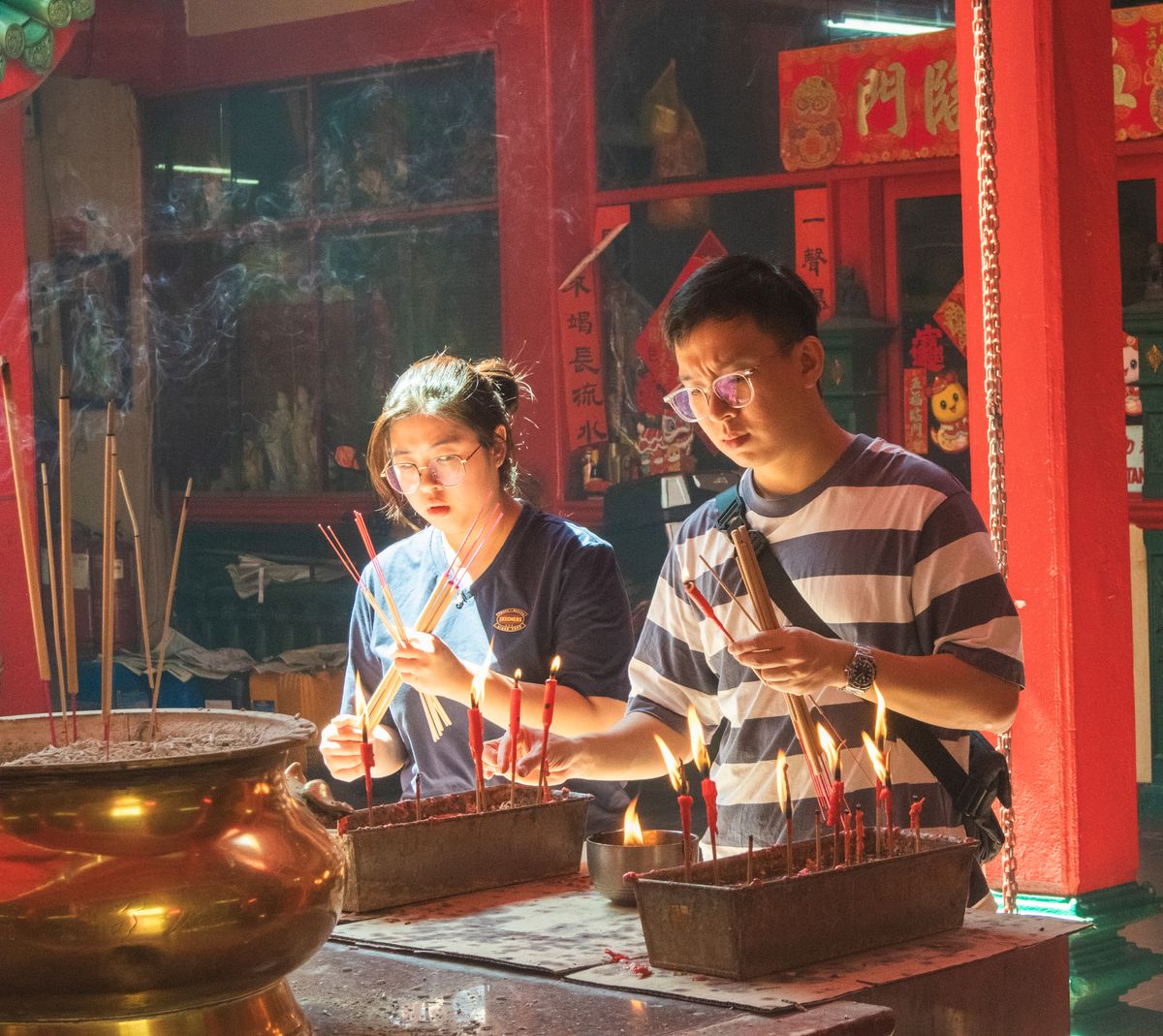 马来西亚传统祭拜空间内有香烛与供品，提醒家属在祭拜前了解场地规则和不同家庭习俗。