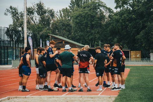 Group of young athletes in a training session on an outdoor running track.