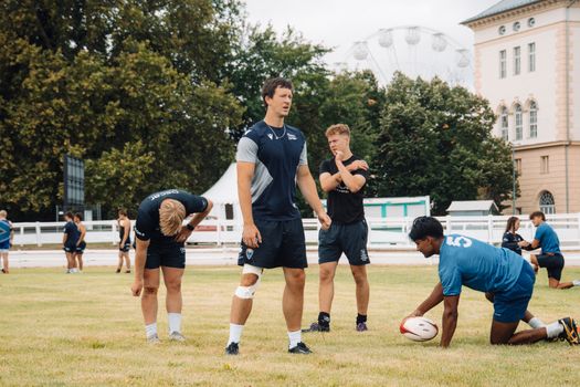Rugby players practice on a field in Budapest, showcasing teamwork and athletic dedication.