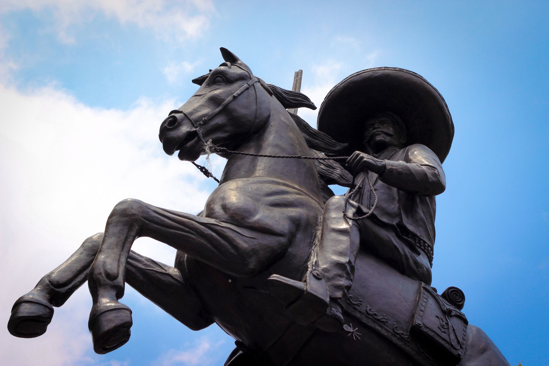 Bronze equestrian statue with Zapata figure in Cuernavaca, Mexico, under a clear sky.