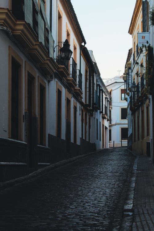 Free Picturesque narrow street in Córdoba, Spain, showcasing traditional architecture and cobblestone path. Stock Photo