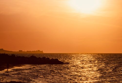 Free Warm sunset over the serene sea in Yalova, Türkiye, with silhouetted coastline. Stock Photo