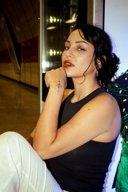 Free Portrait of a fashionable young adult woman with tattoo in an indoor setting, exuding confidence. Stock Photo