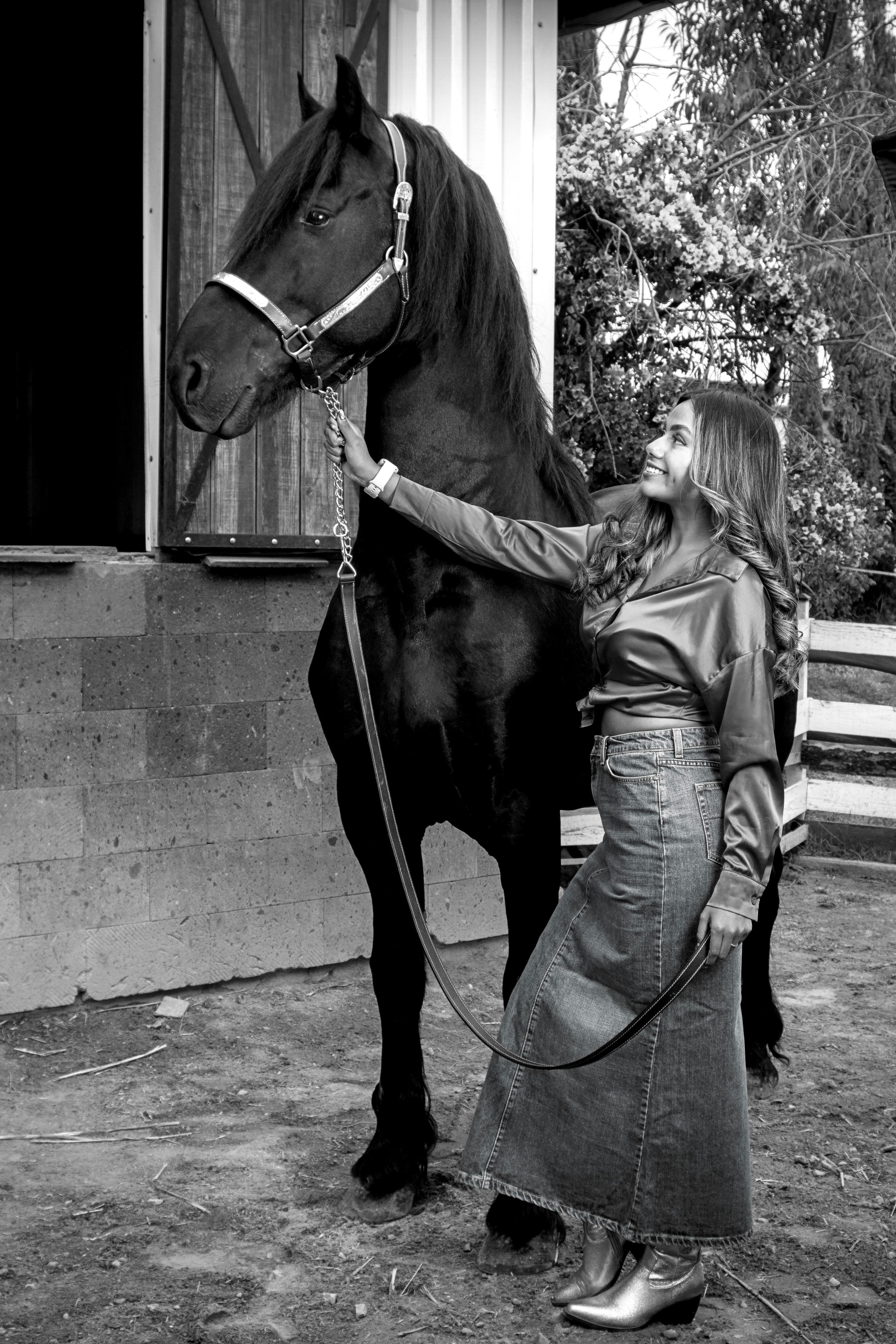 Gratis Una mujer y un caballo negro afuera de un establo en Tlaxcala, México, mostrando elegancia y conexión. Foto de stock