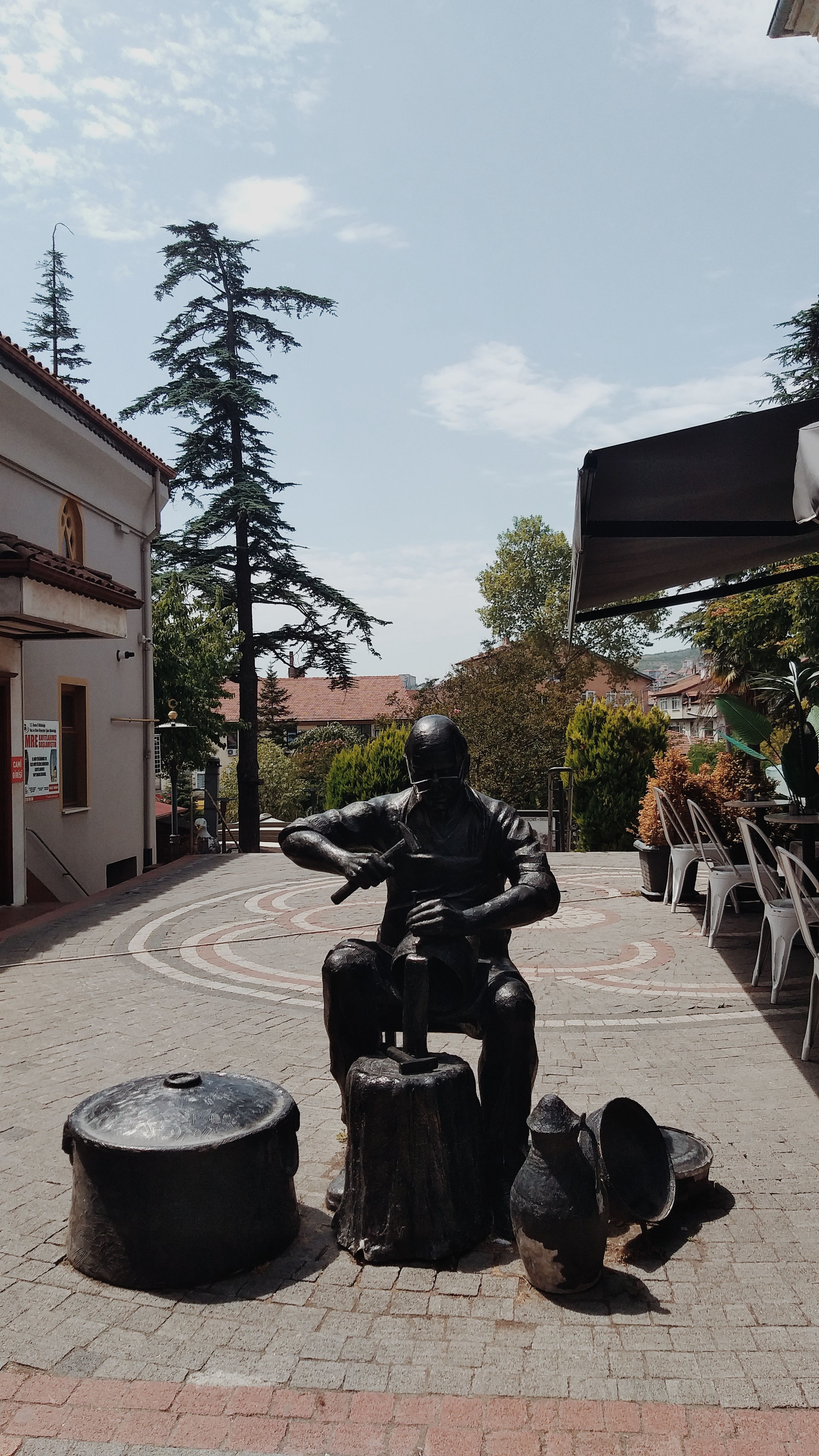 A bronze sculpture of a seated figure in an outdoor café, Bartın, Türkiye.