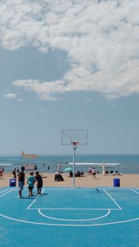 Vibrant beachfront basketball scene in Bartın, Türkiye with people enjoying a sunny day.