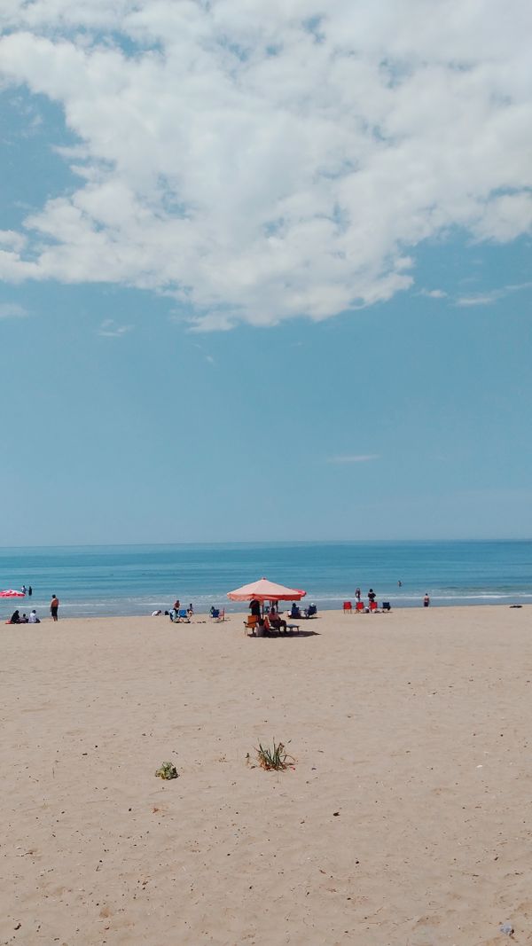 Cena relaxante da praia de Bartın com guarda-sóis e pessoas aproveitando o dia de verão.