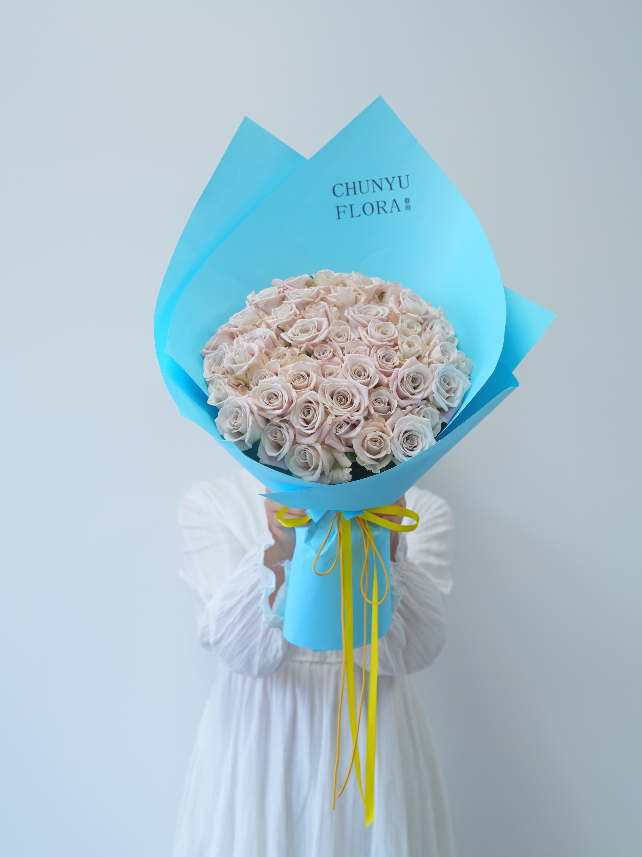 Elegant Bouquet of Pale Roses in Blue Wrapper · Free Stock Photo