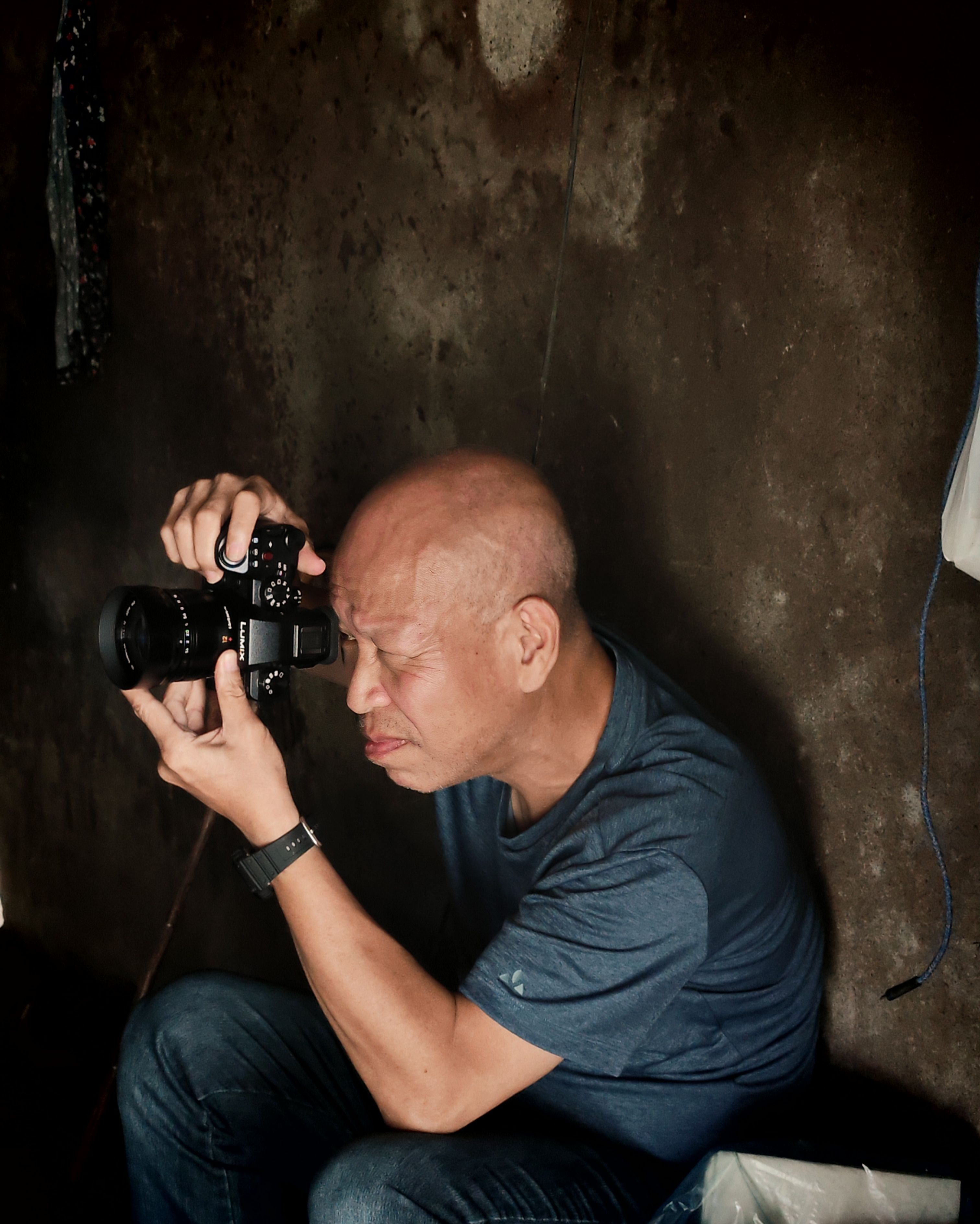 Concentrated man taking a photo indoors, demonstrating focus and determination.