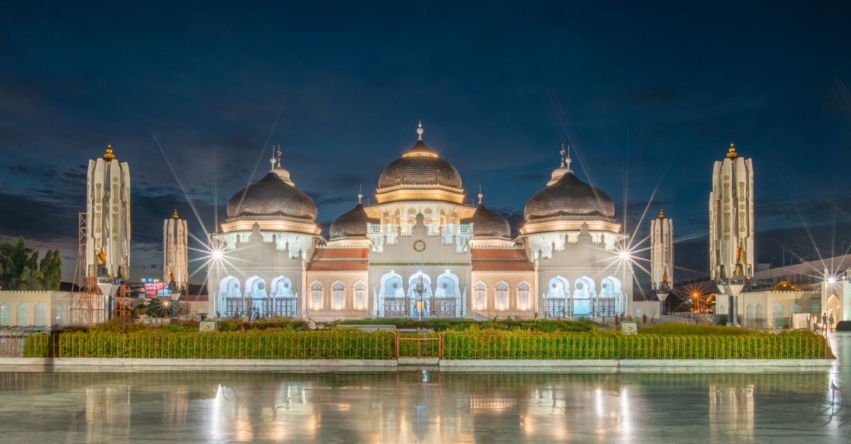 Stunning night shot of the Baiturrahman Grand Mosque in Aceh, Indonesia, showcasing its majestic Islamic architecture.