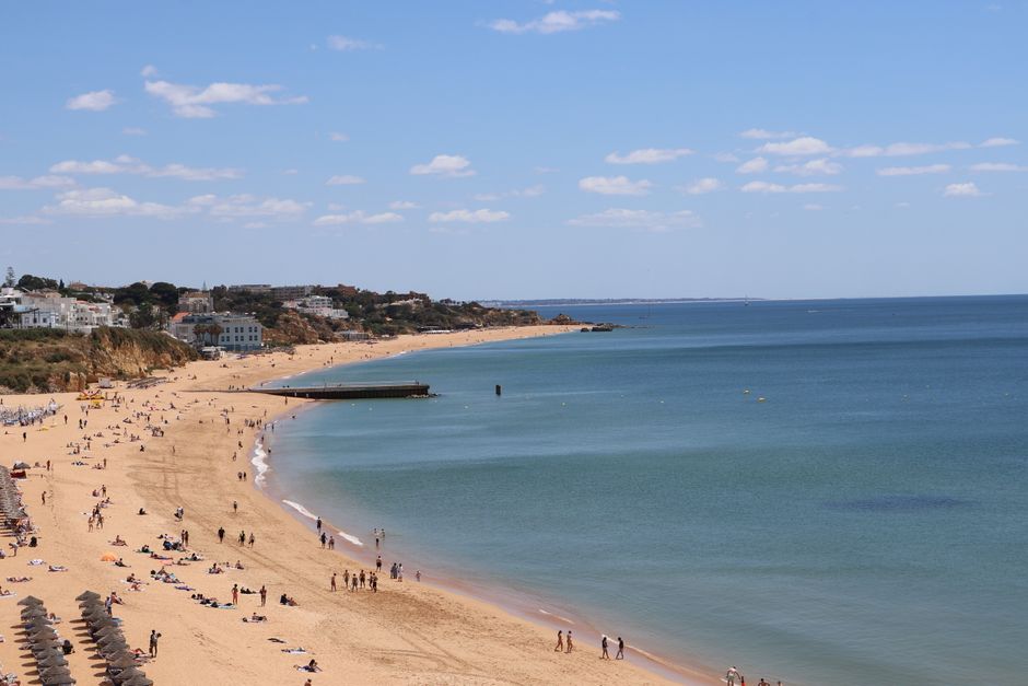 Beautiful sunny beach scene in Algarve, Portugal with clear skies and relaxing atmosphere.