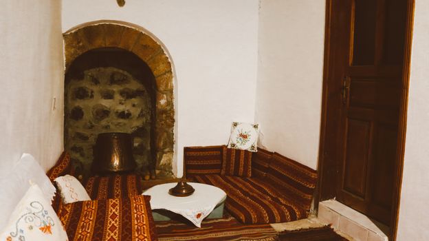Traditional Turkish sitting area featuring vibrant cushions and rustic decor, providing an inviting and warm atmosphere.