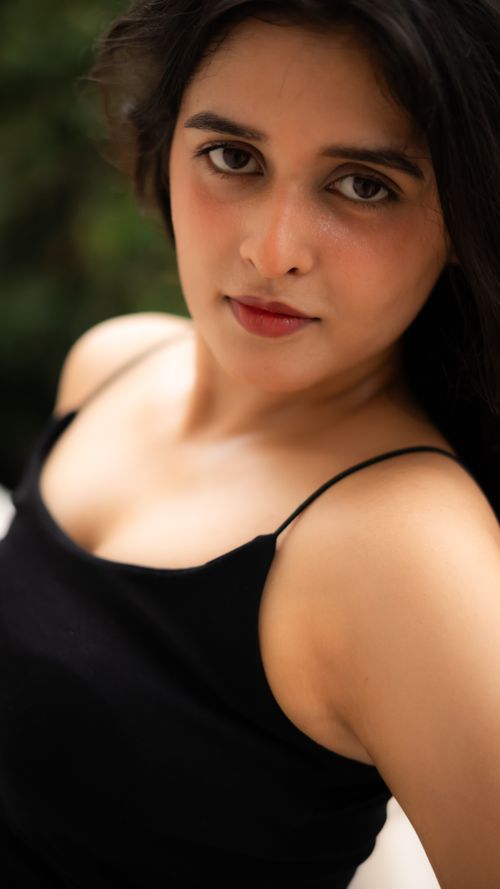 Free Close-up portrait of a young woman in a black top with an intense expression. Stock Photo