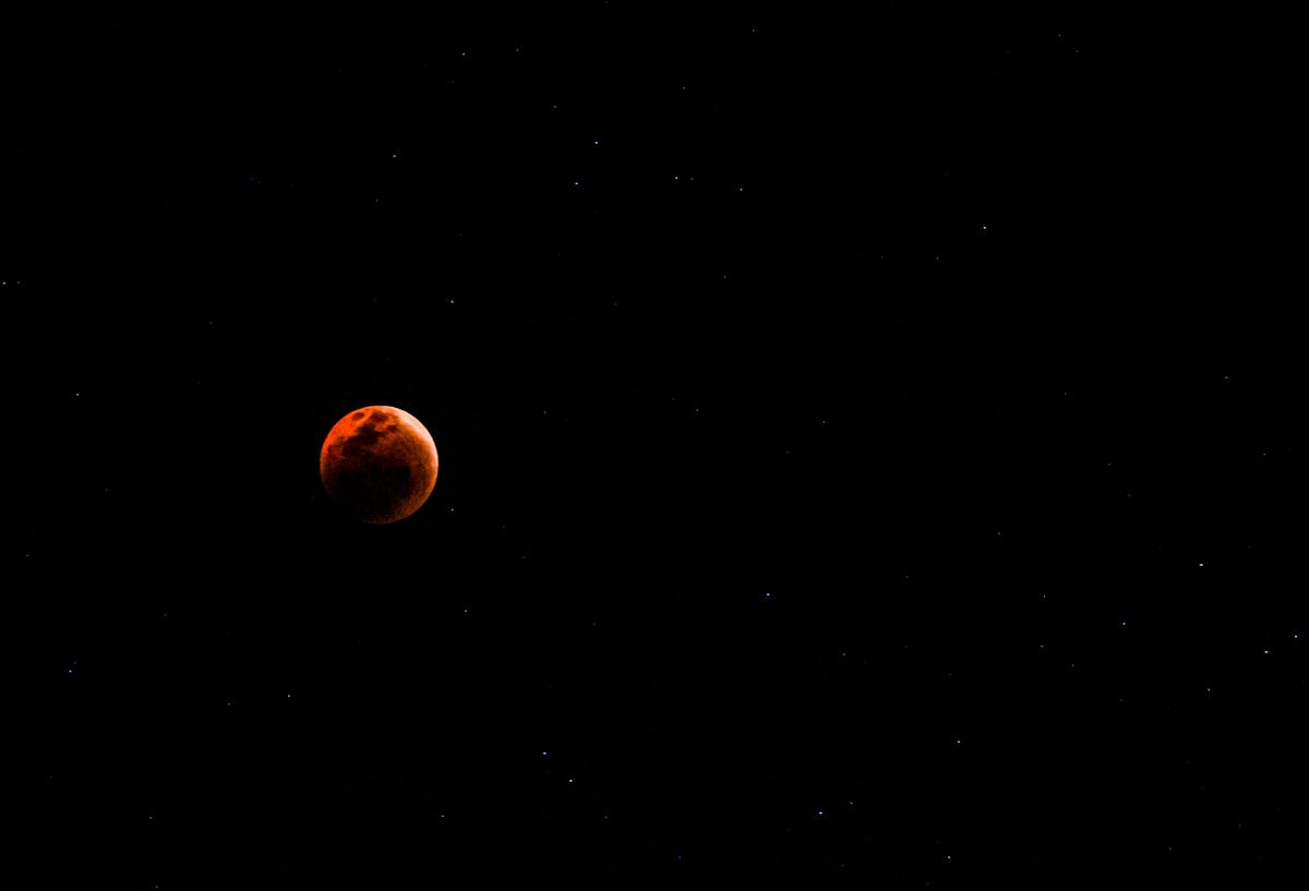 Blood moon against a star-filled night sky