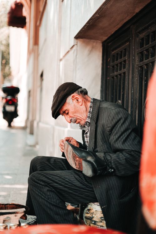 Free An elderly cobbler repairs a shoe on a street in Istanbul, showcasing traditional craftsmanship. Stock Photo