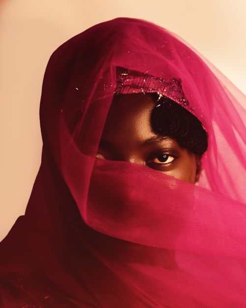 Free Artistic portrait with deep eyes and a vibrant pink veil, evoking mystery and elegance. Stock Photo