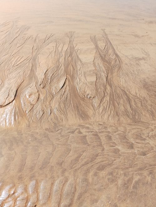 Free Intricate sand patterns created by water on a Casablanca beach, captured from above. Stock Photo