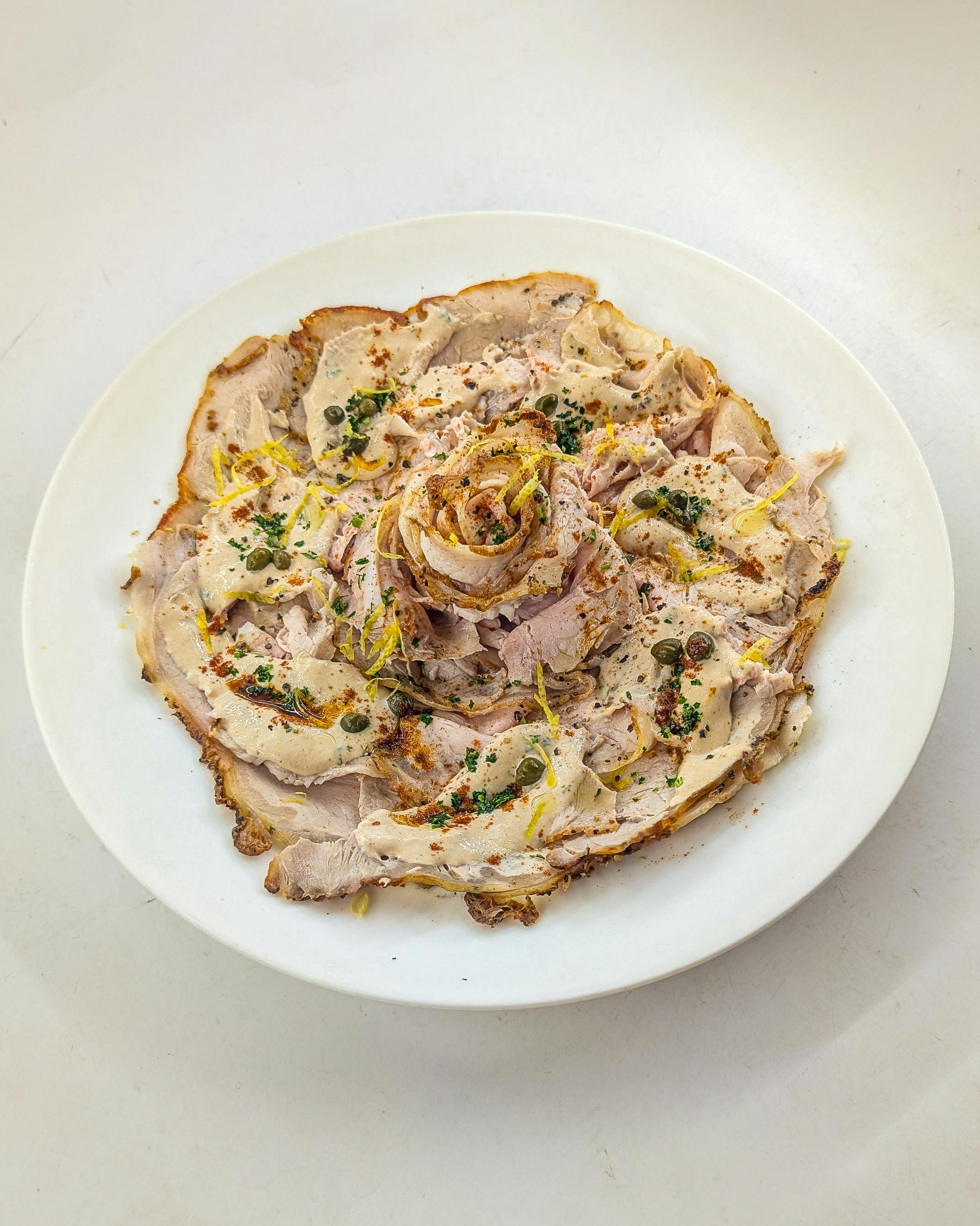 Fette sottili di vitello nappate con salsa cremosa e capperi