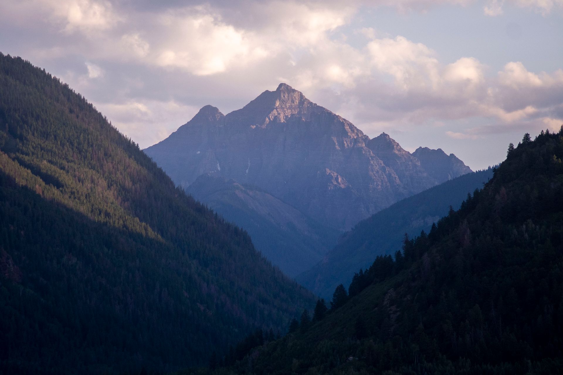 Beautiful mountain landscape with lush forests and dramatic sky, captured in Idaho at sunrise.