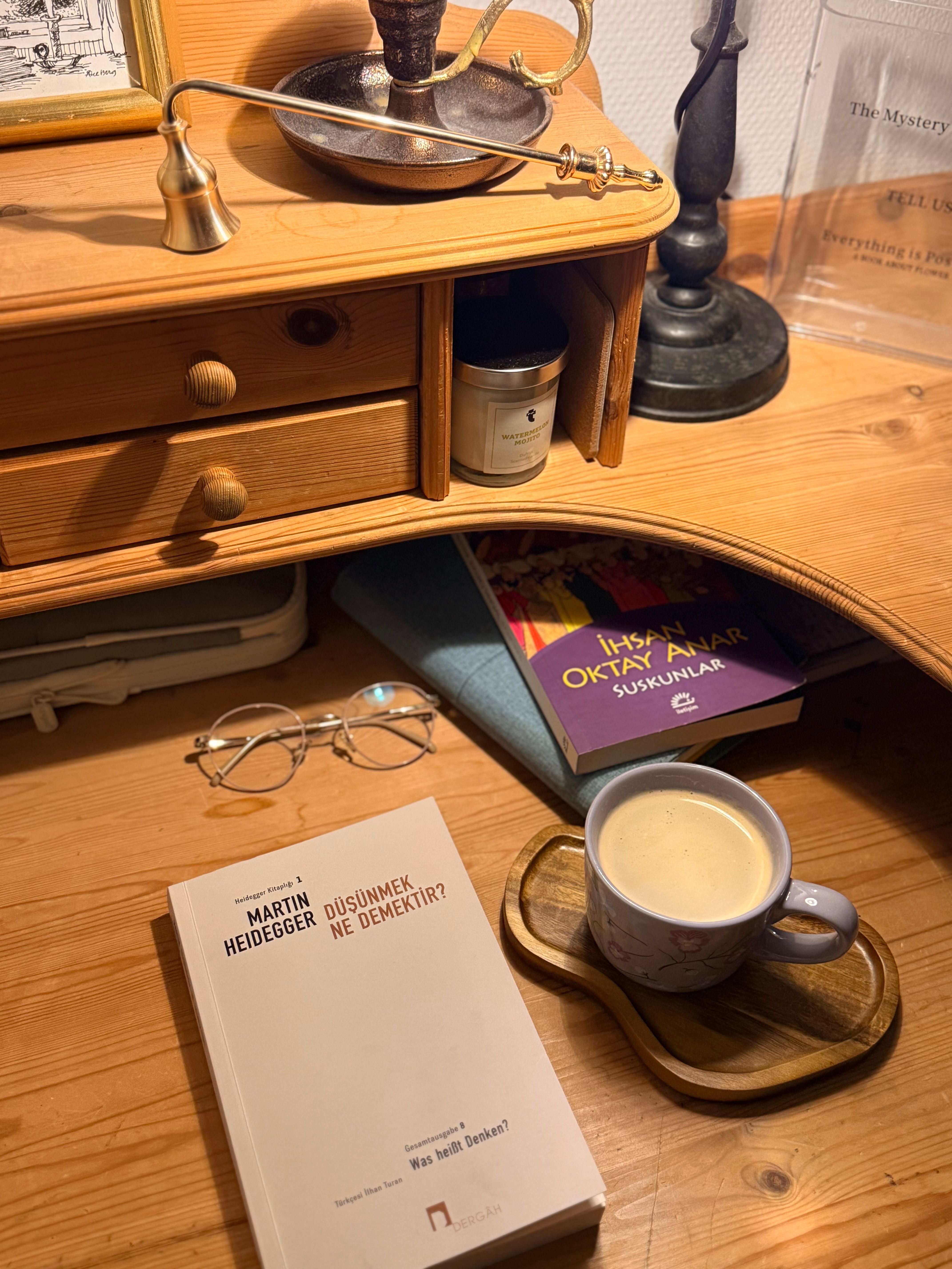 Warm desk scene with books, glasses, and a cozy coffee mug, exuding a scholarly ambiance.
