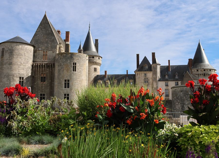 Beautiful view of Sully-sur-Loire Castle with colorful summer flowers in the foreground.