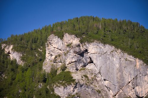 Free Majestic rocky hill with lush greenery under clear blue sky in Trentino-Südtirol. Stock Photo