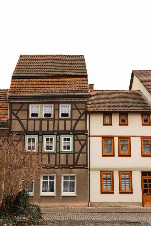 Free A picturesque view of traditional timbered houses on a village street, showcasing classic architectural details. Stock Photo