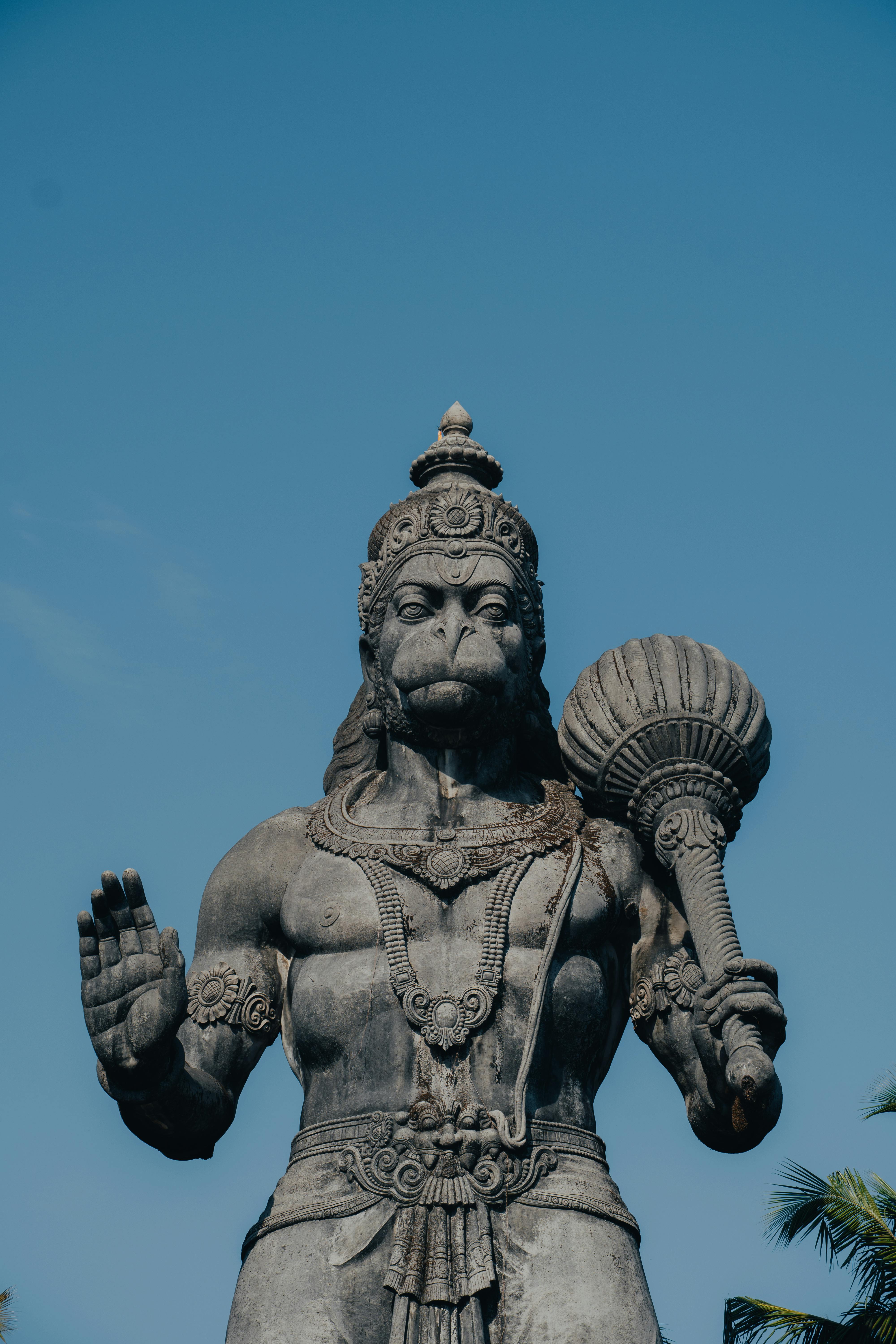Close-up of a grand Hanuman statue in Bengaluru, Karnataka, showcasing intricate details under a clear blue sky.