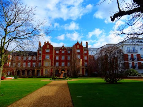 一座宏伟的红砖豪宅，在阳光照耀下，映衬着充满活力的蓝天和郁郁葱葱的花园