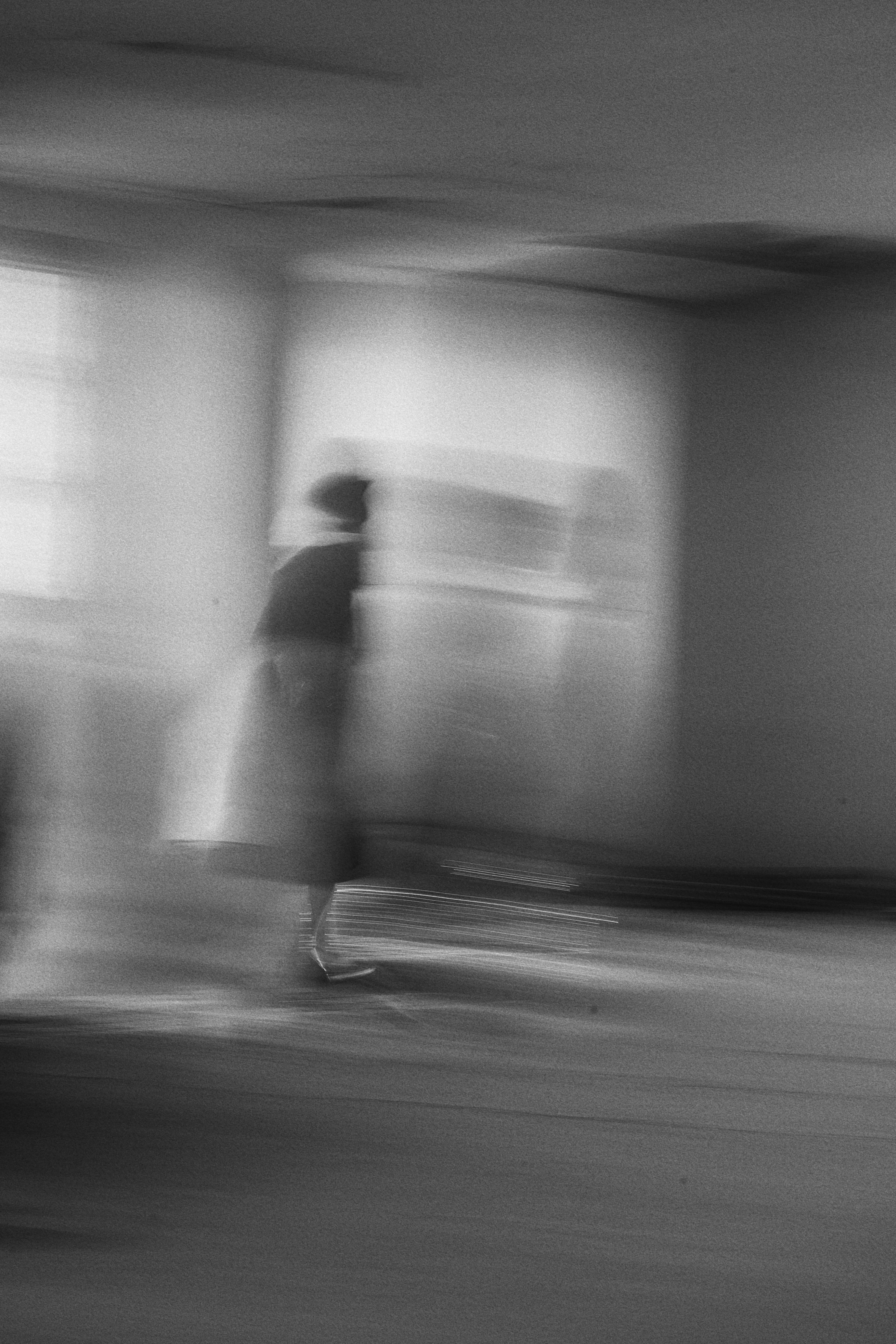 grátis Imagem abstrata em preto e branco de uma mulher borrada em movimento dentro de uma sala. Foto profissional