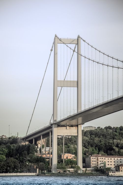 Free View of the Bosphorus Bridge spanning Istanbul's scenic skyline, showcasing its iconic structure. Stock Photo