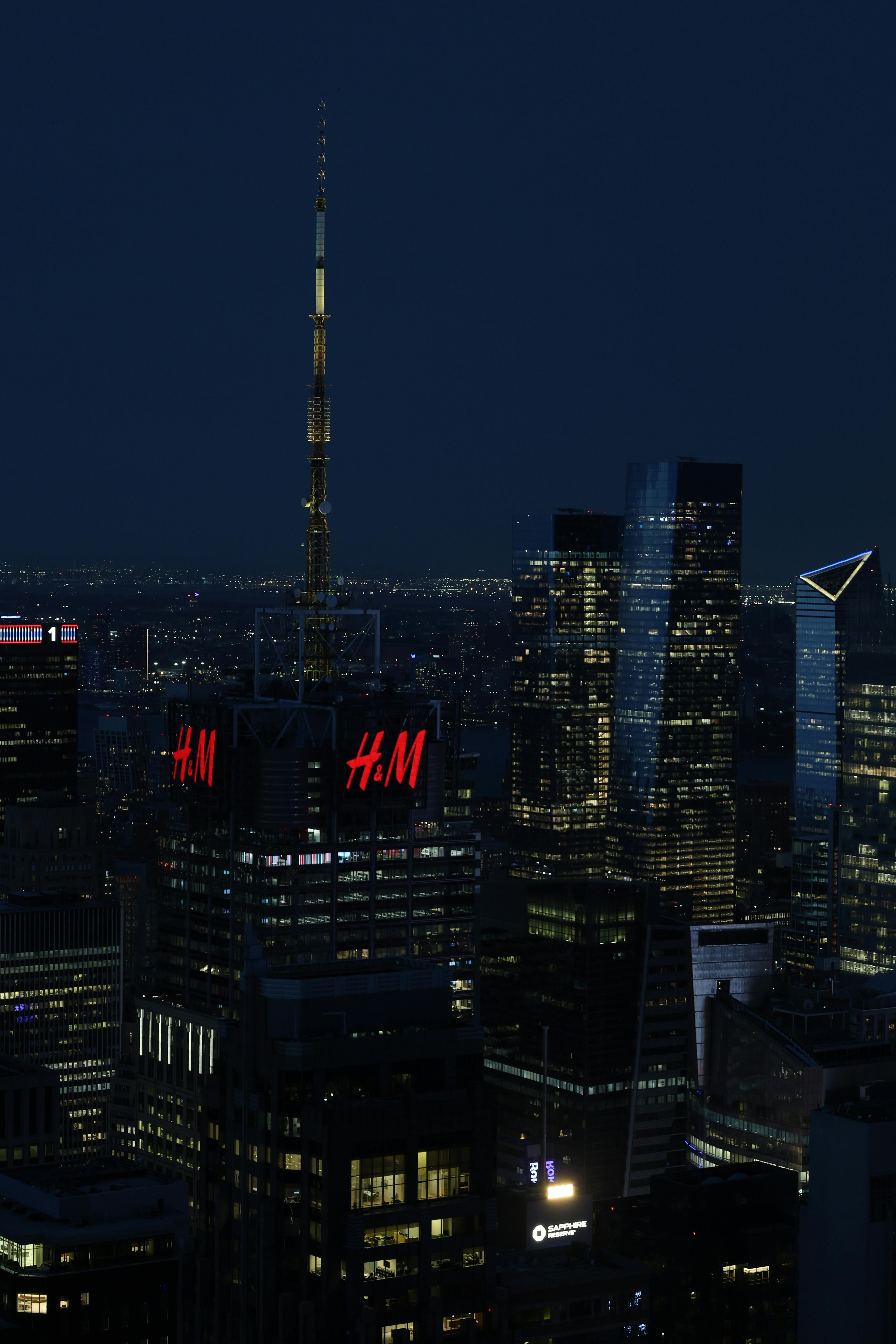 High-rise buildings illuminated in New York City at night.
