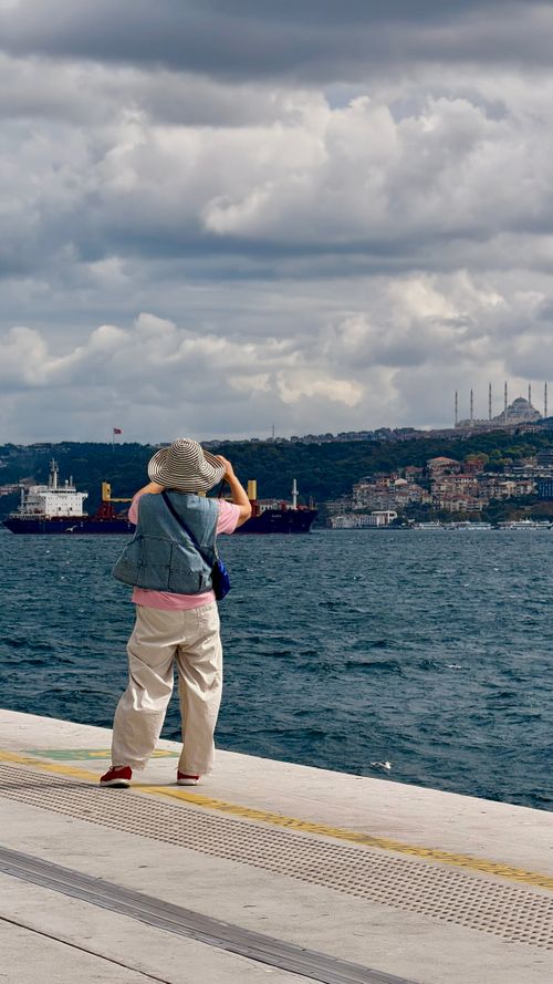 Free A tourist captures the scenic view of Istanbul's skyline and Bosporus Strait. Stock Photo