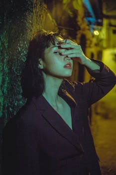 这是一幅在夜间用明亮灯光拍摄的、一位吸烟妇女的戏剧性肖像