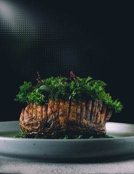 Delicious roasted beef with fresh herbs on white plate, perfect for gourmet presentations.